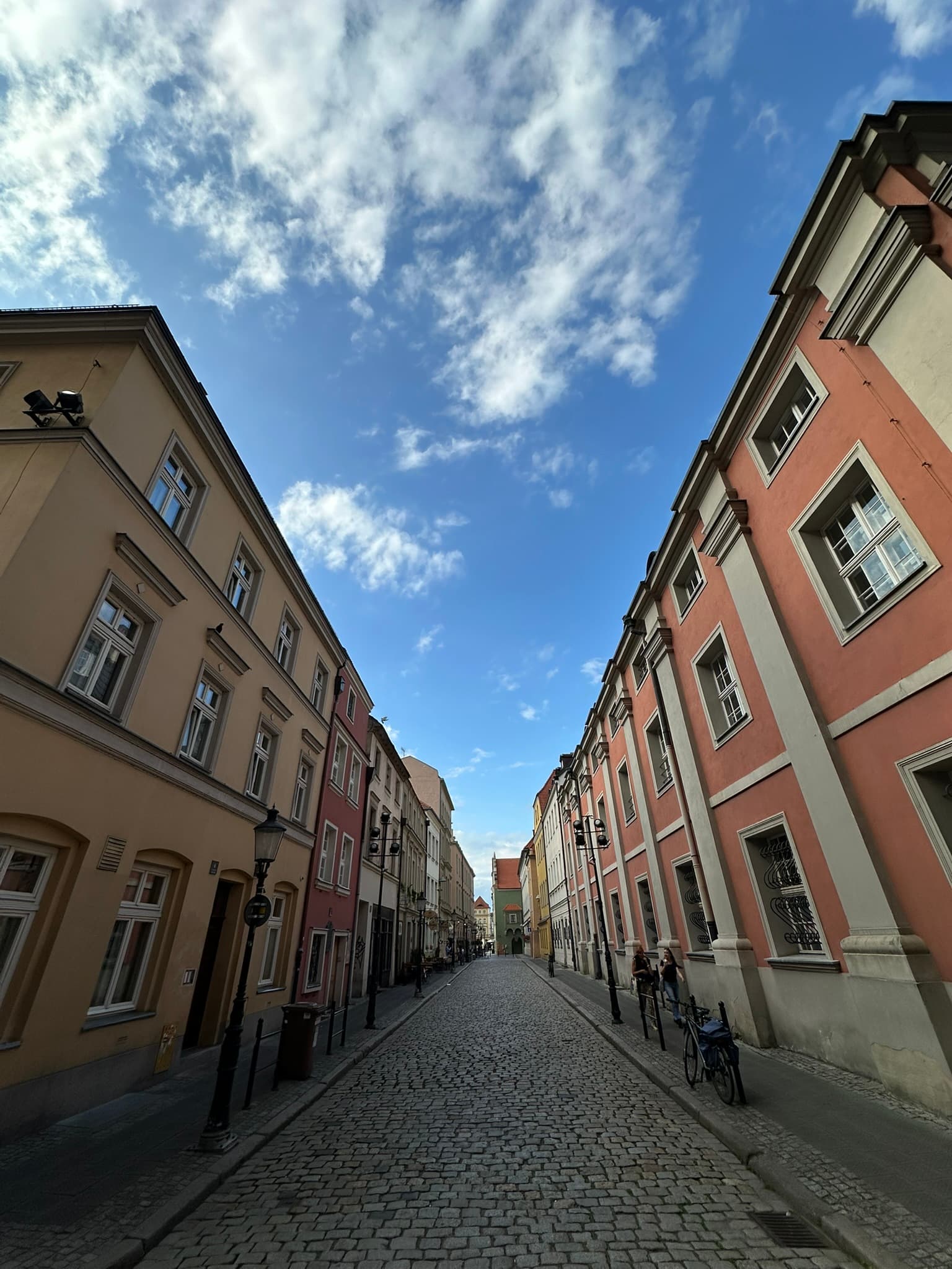 A quiet cobblestone street framed by colorful buildings in Poland