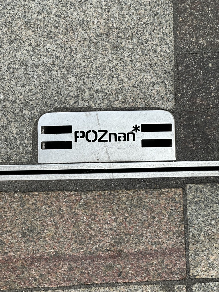 A small Poznań detail embedded in the pavement